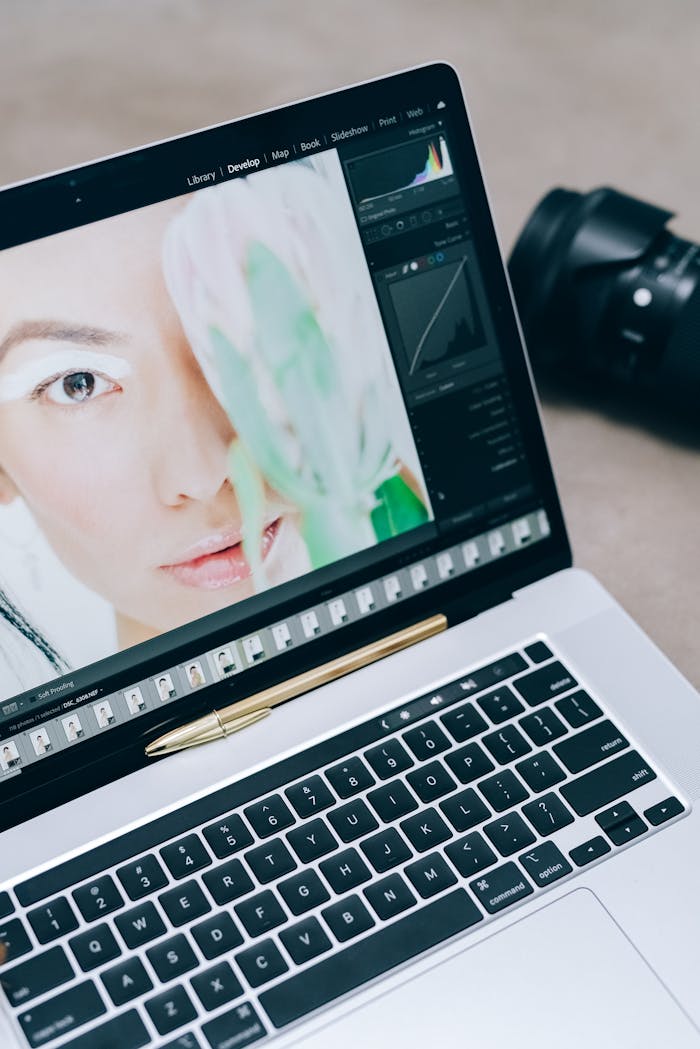 Close-up of a laptop displaying portrait editing with a camera nearby, ideal for photographers.